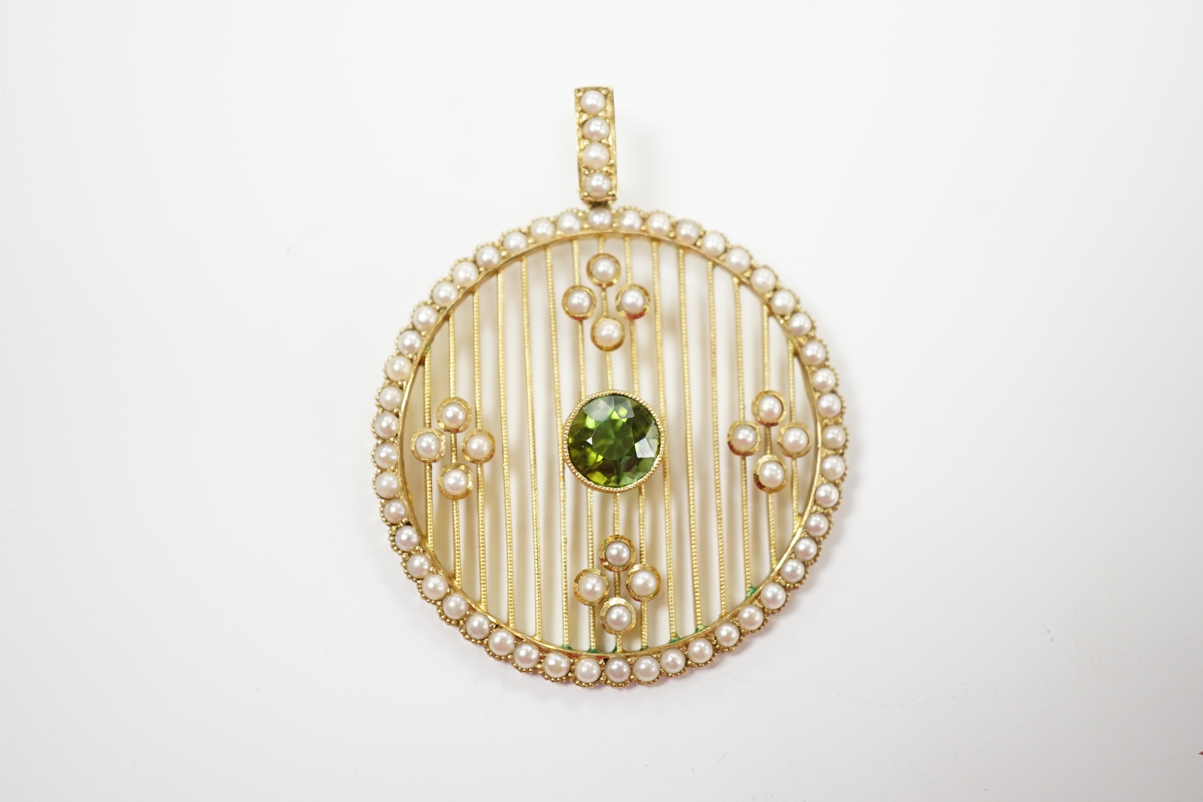 An Edwardian 15ct, green tourmaline and seed pearl cluster set circular pearl pendant, overall 41mm, gross weight 7 grams.
